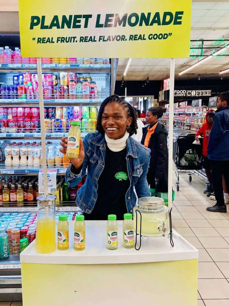 Entrepreneur Nthabiseng Mokaraoke with Planet Lemonade products at a retail stand